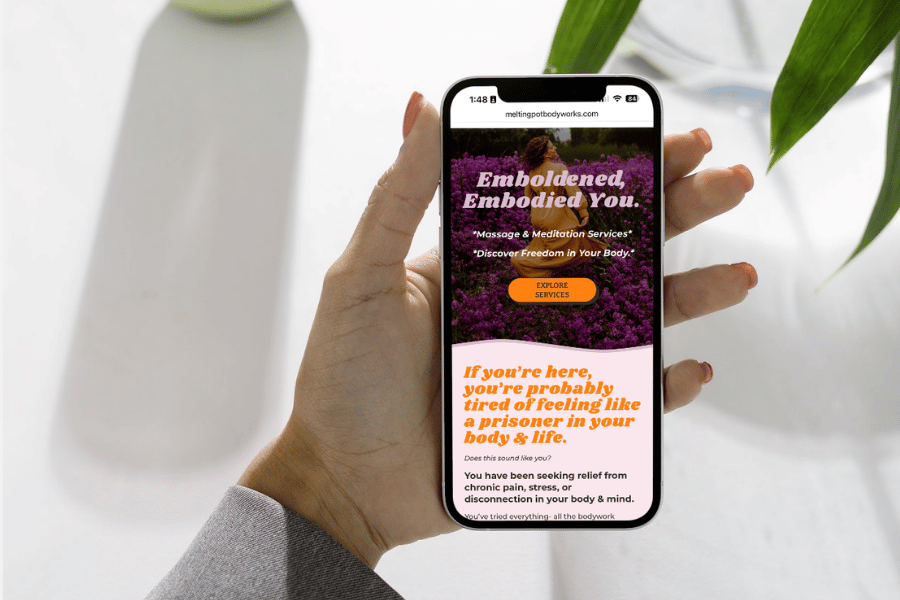 Hand holding a phone showing the Melting Pot Bodyworks mobile site