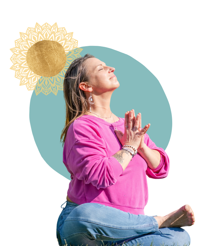 Yoga coach in a pink top meditating with hands in prayer pose